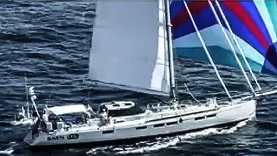 The image shows a large white sailboat with a blue, red, and white sail. The sailboat is in the water with waves visible around it. The name of the sailboat is "Sundeer 64" written on the side.