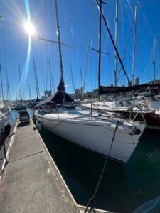 J130 with a white hull and dark boom tent and blue sky tied up in sydney after the yacht delivery